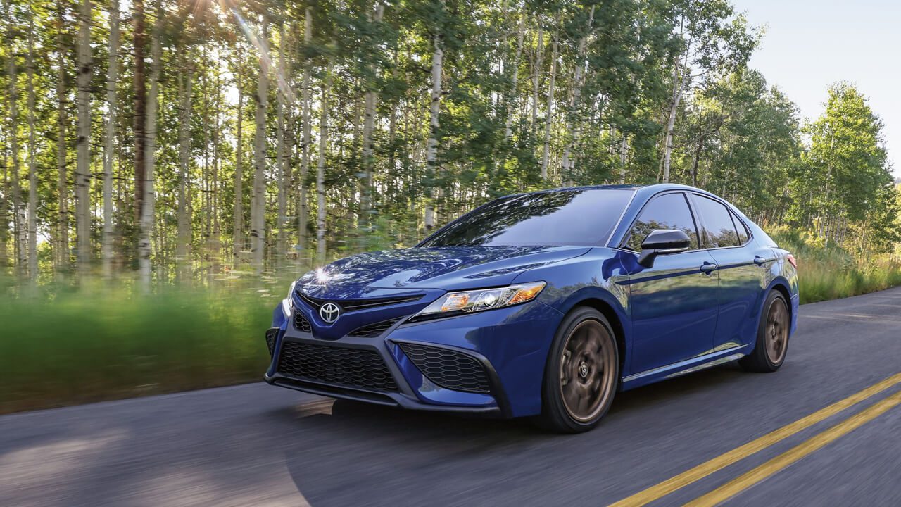 Blue 2024 Camry driving in the countryside