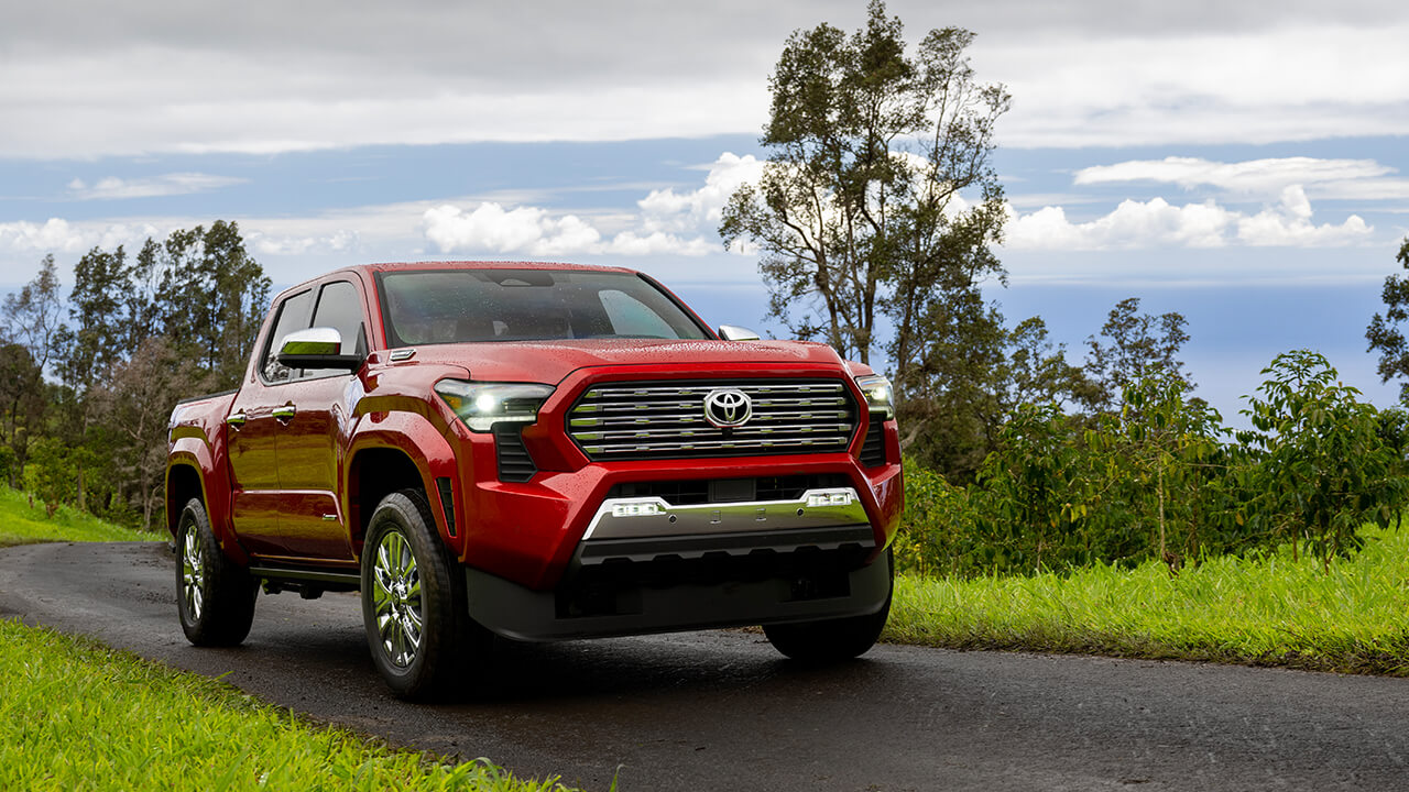 Red 2024 Toyota Tacoma driving in the countryside