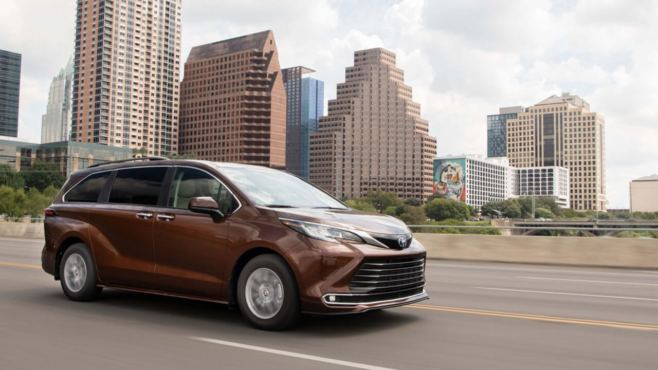 Brown 2024 Toyota Sienna driving in the city