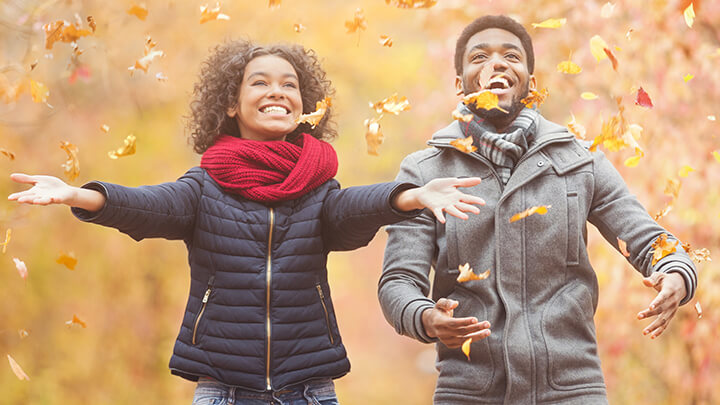 Couple playing in the fall leaves