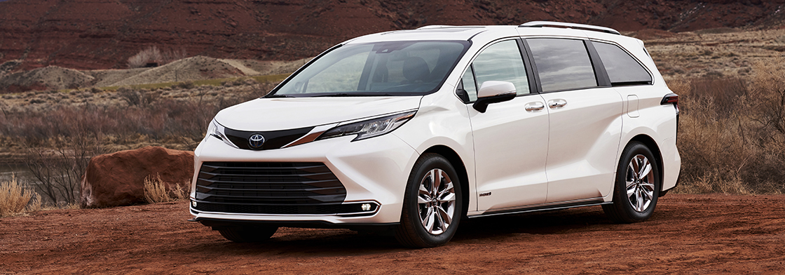 A white Sienna rests in a desert field. 