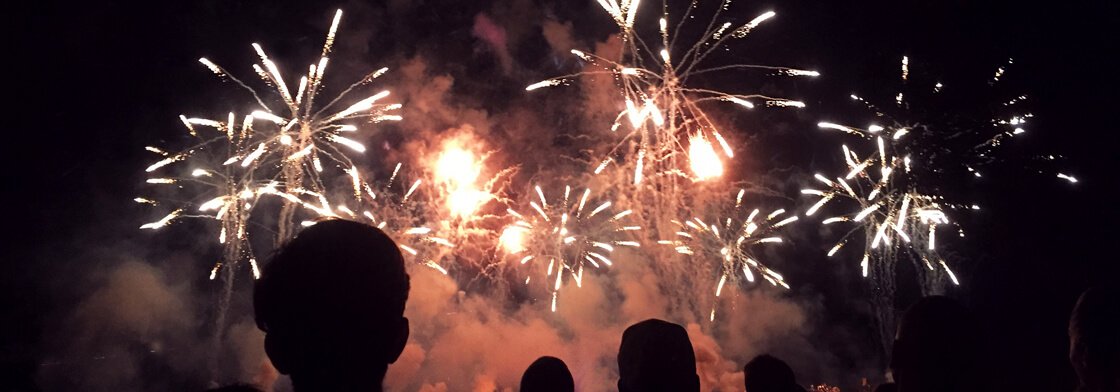 A crowd watching fireworks at night