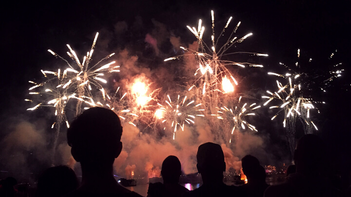 A crowd watching fireworks at night