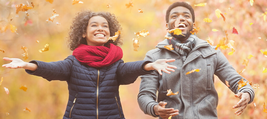 Couple playing in the fall leaves