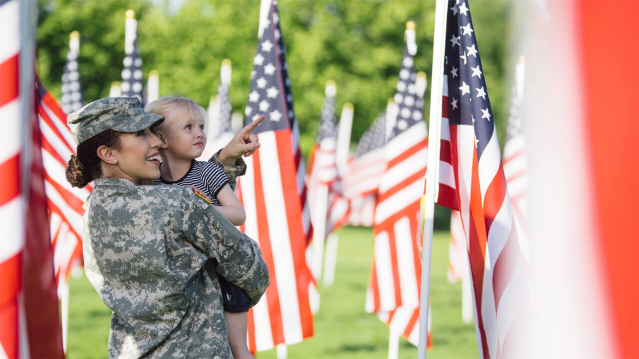 Military woman with child, flags in background