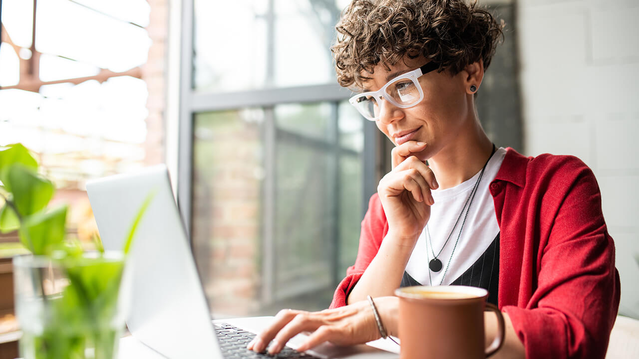 Woman on a laptop wearing a red sweater